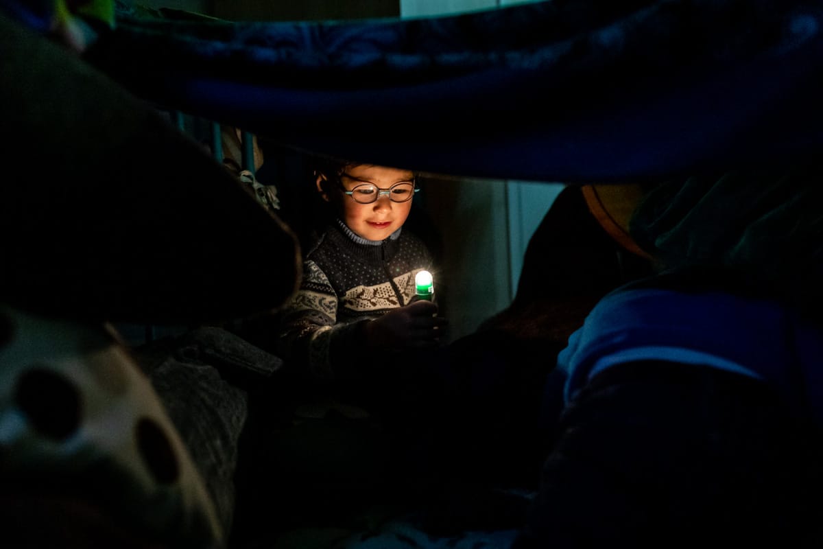 Dokumentarische Familienfotografie. Ein Junge mit Taschenlampe.