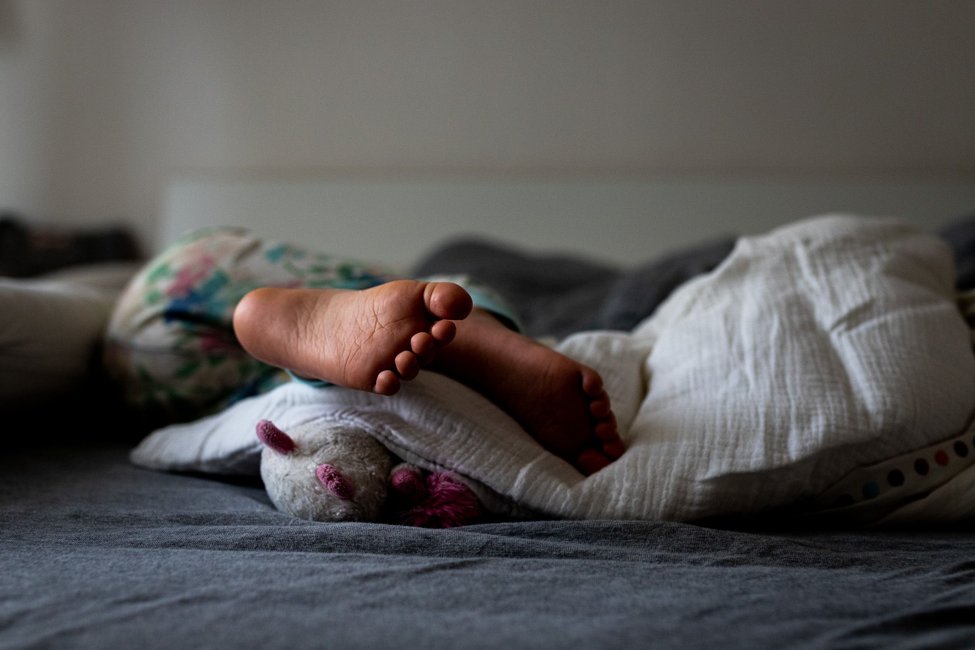 Kinderfüße im Bett.
