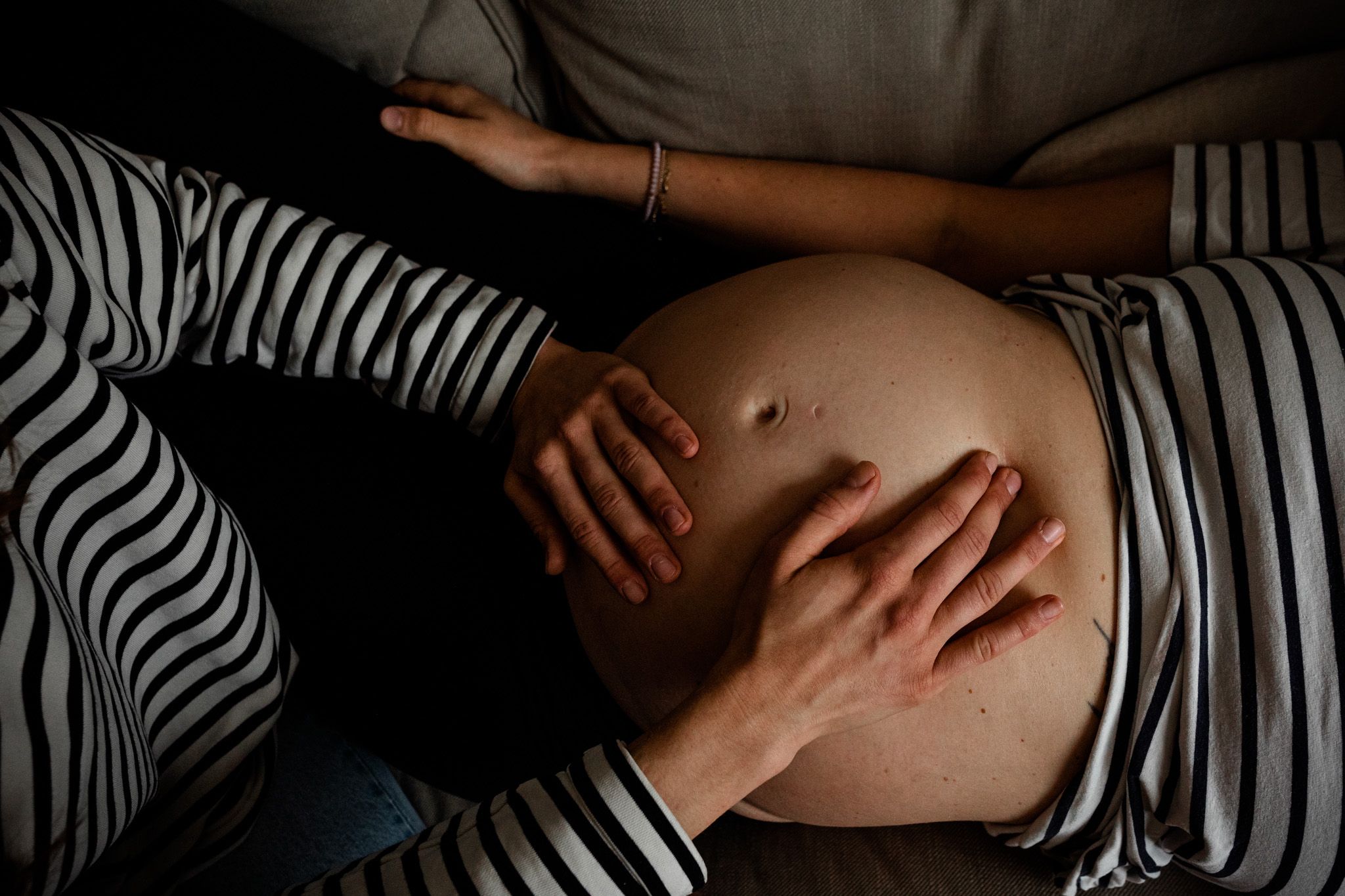 Hände untersuchen einen Schwangeren-Bauch