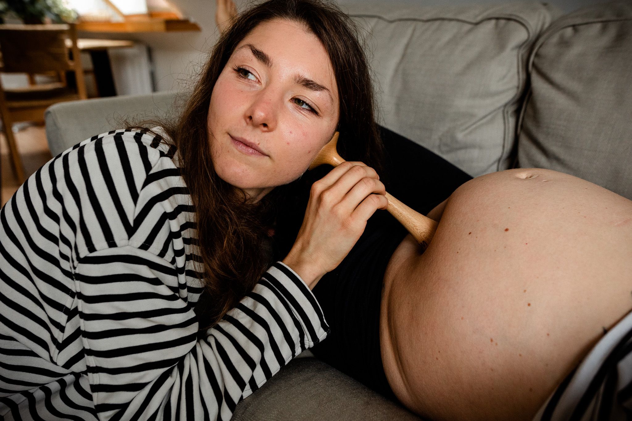 Eine Hebamme hört den Bauch einer Schwangeren ab nach Herztönen