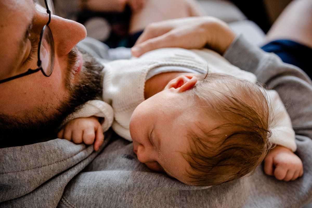 Papa mit Baby im Arm.
