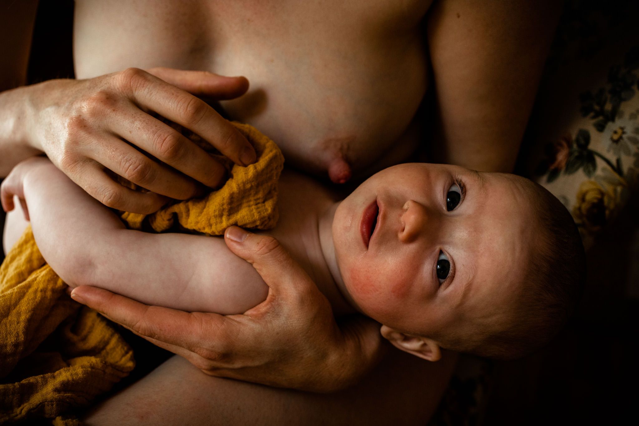 Baby auf dem Arm seiner Mutter, guckt in die Kamera