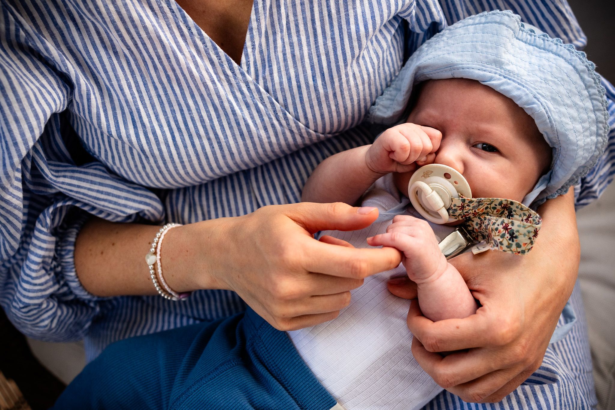 Baby bei einem Babyshooting auf dem Schoß der Mutter.