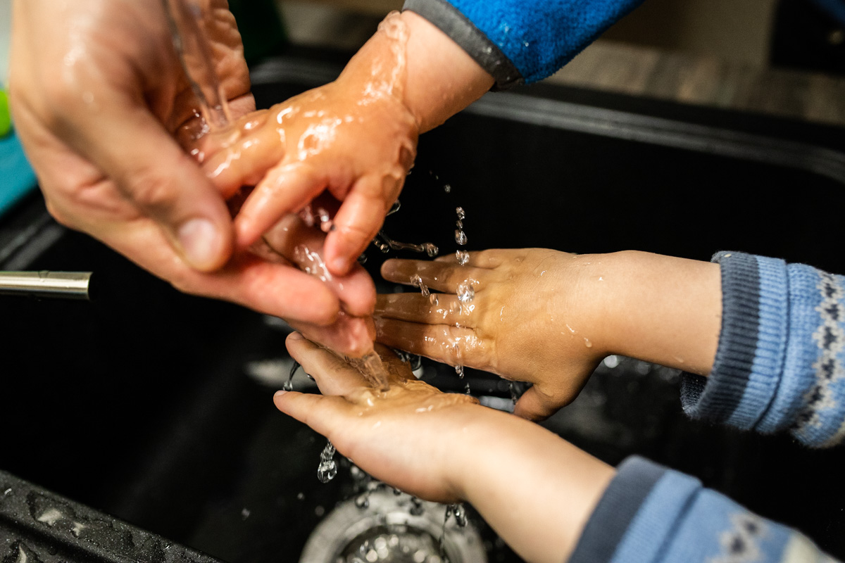 Familienalltag. Kinderhände beim Händewaschen.