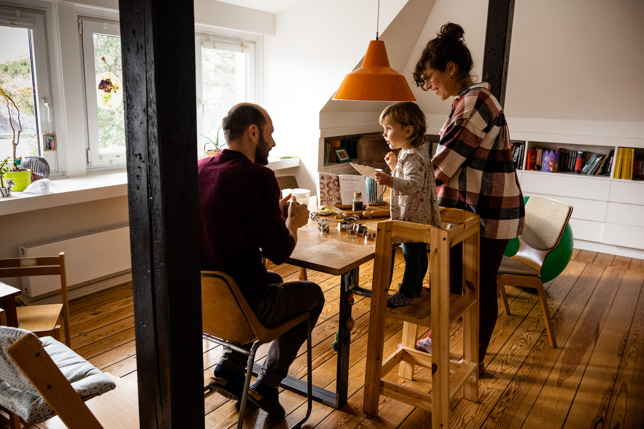 Familienreportage in Hamburg: Vater, Mutter und Tochter im Wohnzimmer beim gemeinsamen Backen
