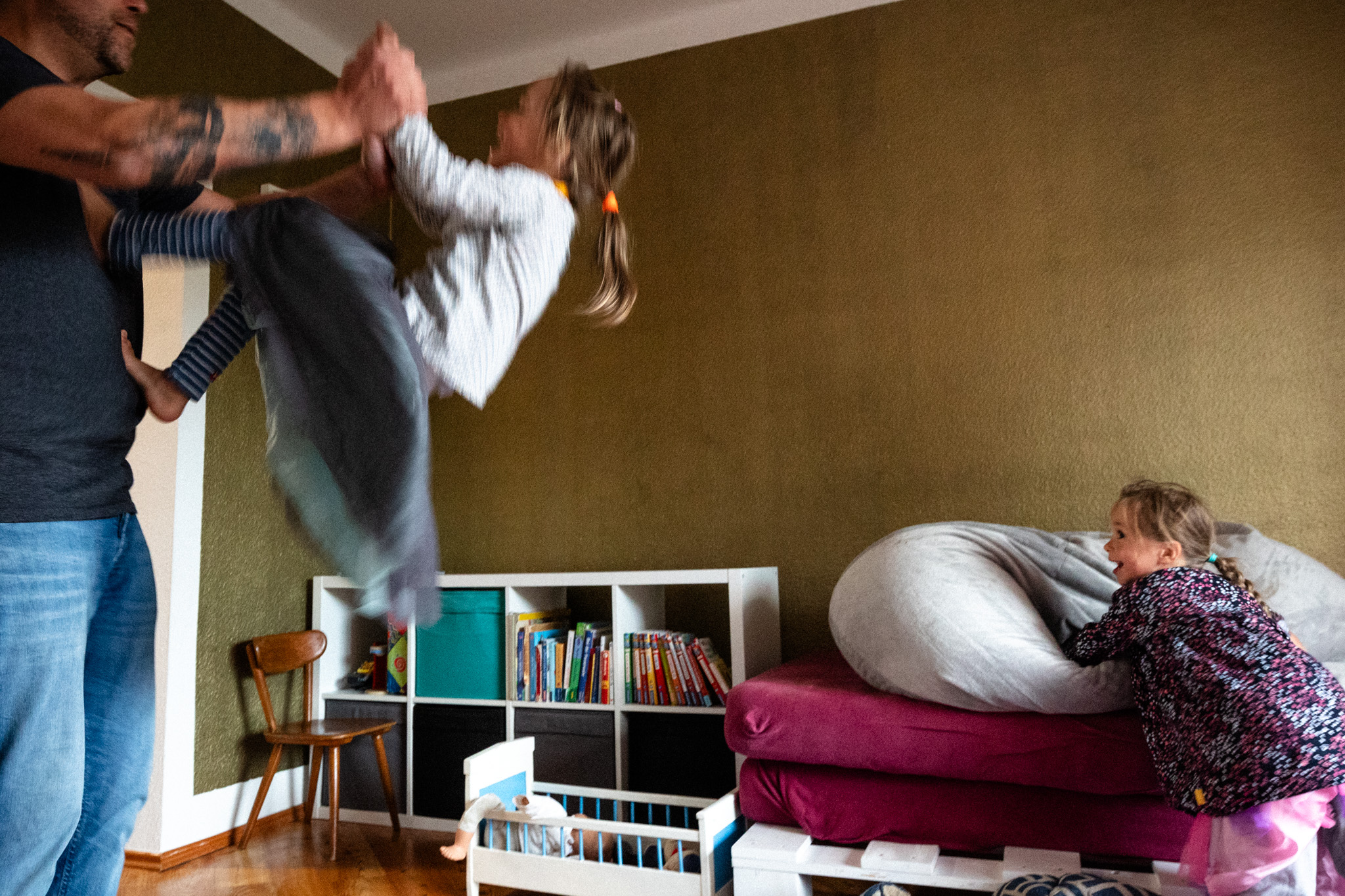 Vater tobt mit seinen Töchtern im Kinderzimmer